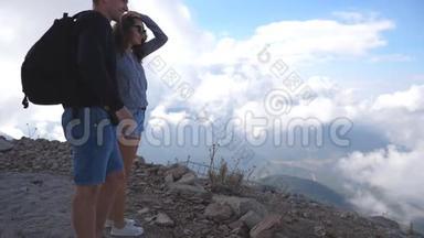 年轻的一对游客<strong>站在山顶</strong>，看着美丽的风景向前他们。 男子和妇女